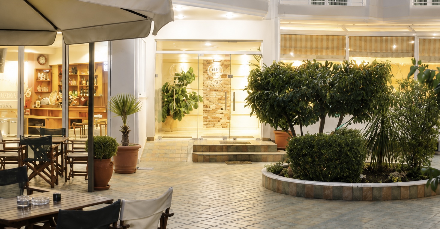Warmly lit hotel entrance and courtyard seating in the evening